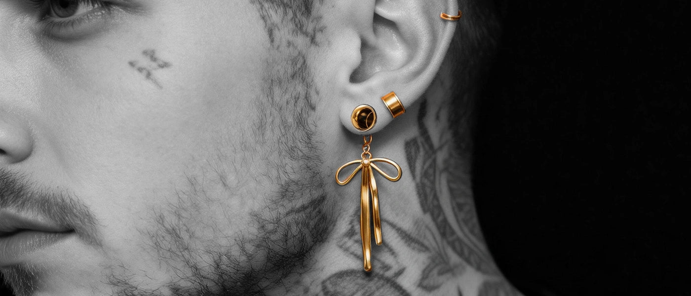 A stylish close-up portrait of a model, featuring decorative metallic ear-weights hanging from both stretched earlobes.