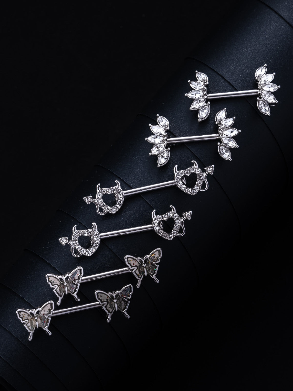 Three sets of close-up photographs of nipple rings.