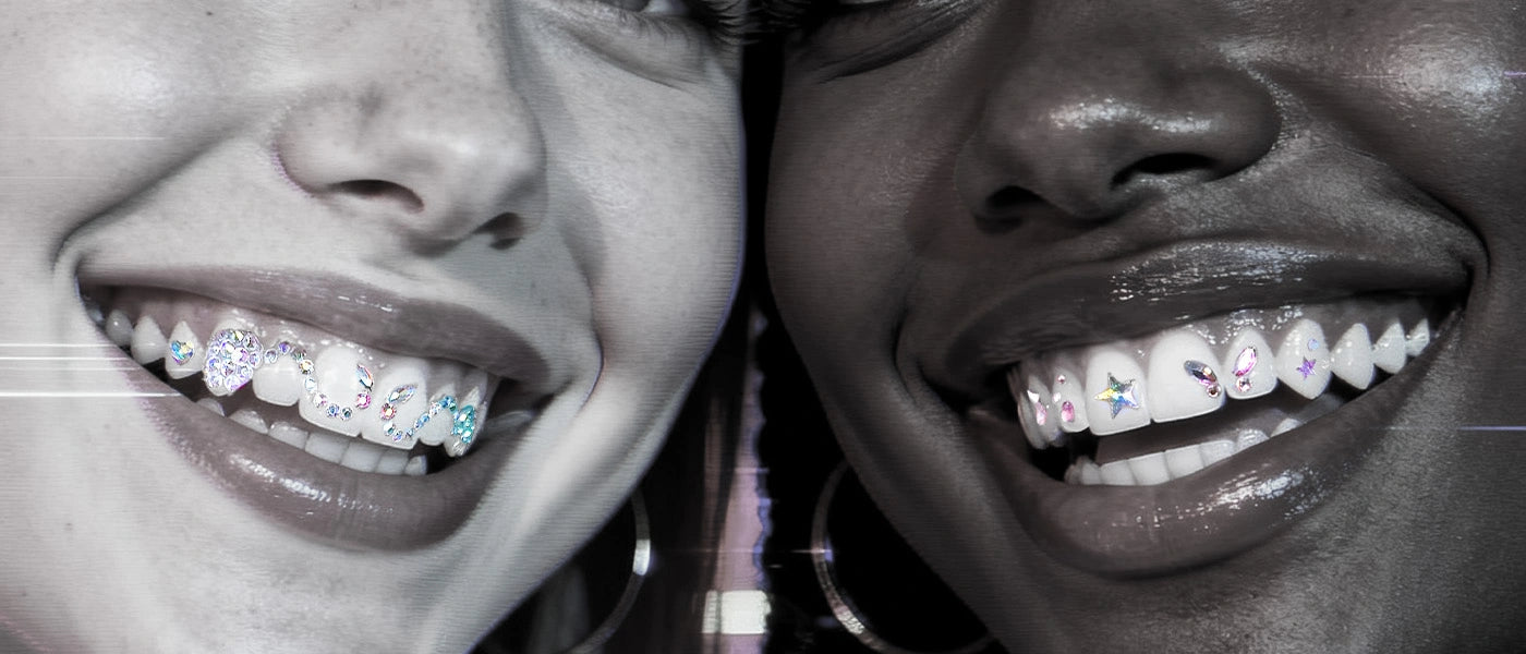 A close-up of a model's smile, showcasing a small, sparkling jewel or crystal adornment on the surface of a tooth.